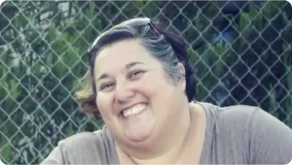 osoba usmievajúca sa pred drôteným plotom