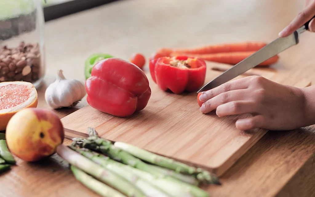 osoba krájející zeleninu nožem