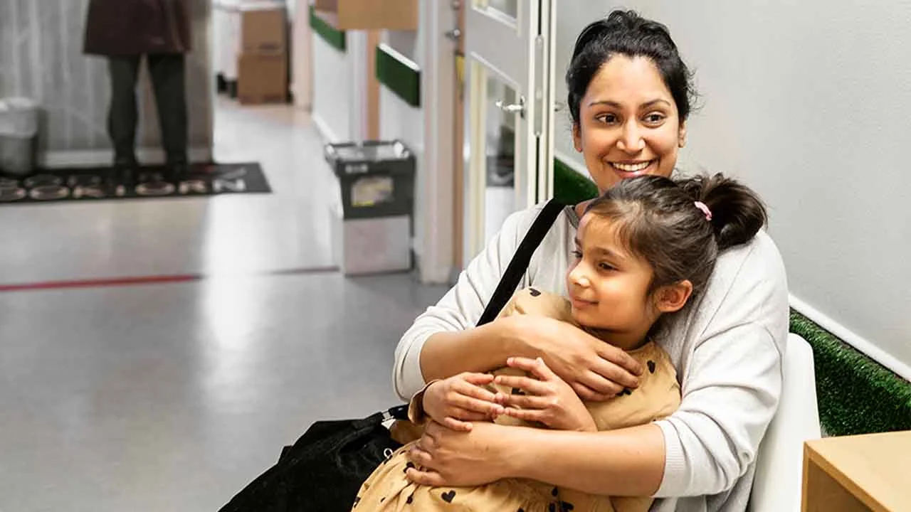 En kvinne holder et barn i armene sine